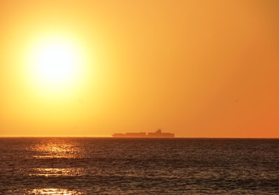At sunset the outline of ships at sea
